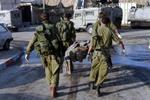 En af de fire israelske soldater, som blev dræbt, bæres væk. - Foto: AP 