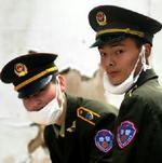 Sikkerhedsvagter i Beijing slækker på maskerne. - Foto. AP 