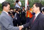 Den nordkoreanske delegerede, Byung Chul (tv), hilser på sin sydkoreanske kollega Myong-kyun. Den nordkoreanske herre ønskede en større fest, men måtte nøjes med et håndtryk. - Foto: AP 