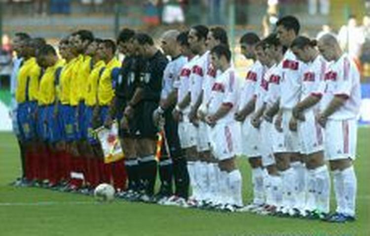 De to hold tav i et minut efter Marc-Vivien Foes tragiske dødsfald i torsdagens kamp mellem Cameroun og Colombia. - Foto: AP 
