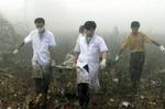 Redningsfolk bærer omkomne ud fra den udbrændte fabrik. - Foto: AP 