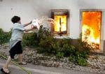 En kvinde i landsbyen Torre i det centrale Portugal er gået til kamp mod flammerne med vandspanden. - Foto: AP 