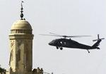 En amerikansk helikopter hænger over markedspladsen i Tikrit, hvor snigskytter fredag skød tre irakere. - Foto: AP 