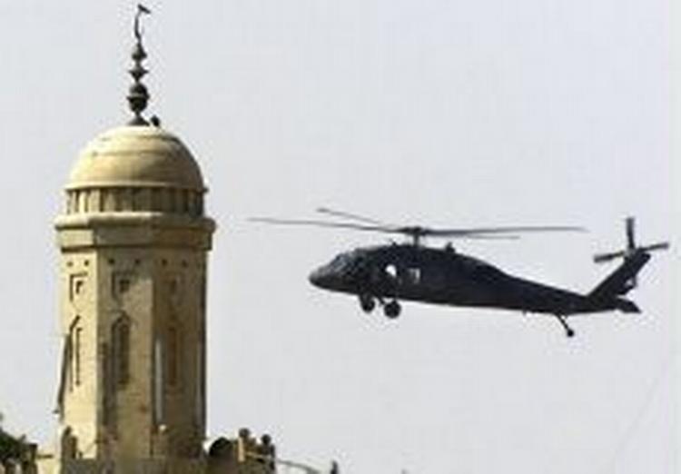 En amerikansk helikopter hænger over markedspladsen i Tikrit, hvor snigskytter fredag skød tre irakere. - Foto: AP 
