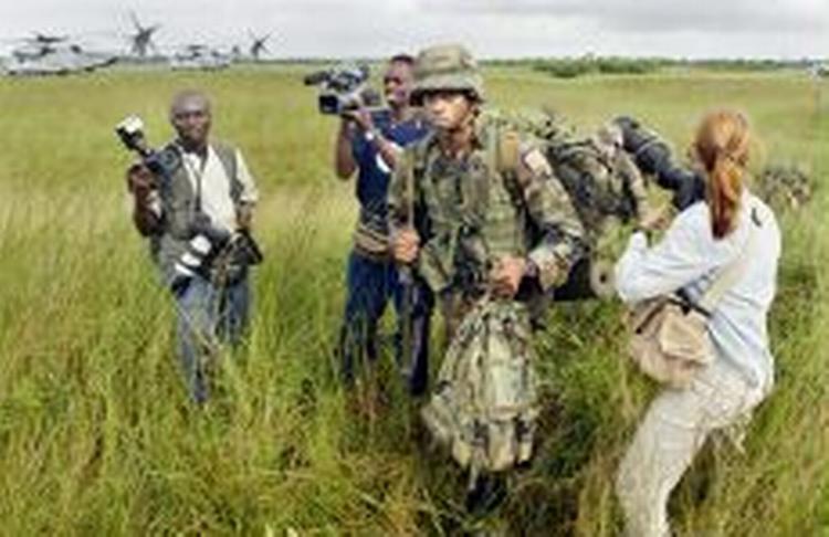 De amerikanske soldater blev mødt af pressen, da de landede i lufthavnen uden for Monrovia. - Foto: AP 