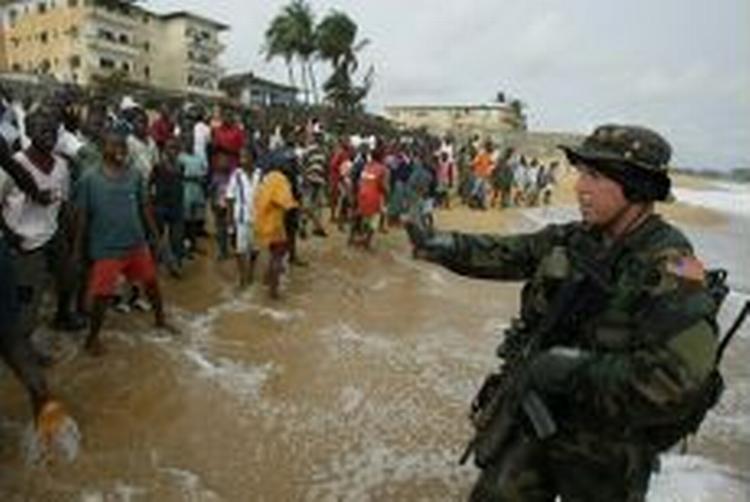 Et hold amerikanske soldater gik i land i Monrovia og blev modtaget af jublende indbyggere. - Foto: AP 