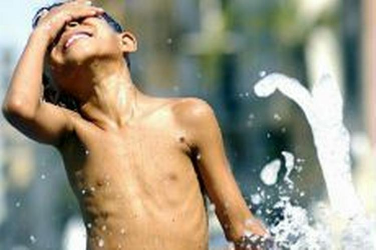 En dreng køler af i et springvand i den sydspanske by Cordoba tidligere på måneden. Her nåede temperaturerne over 40 grader. - Foto: AP 