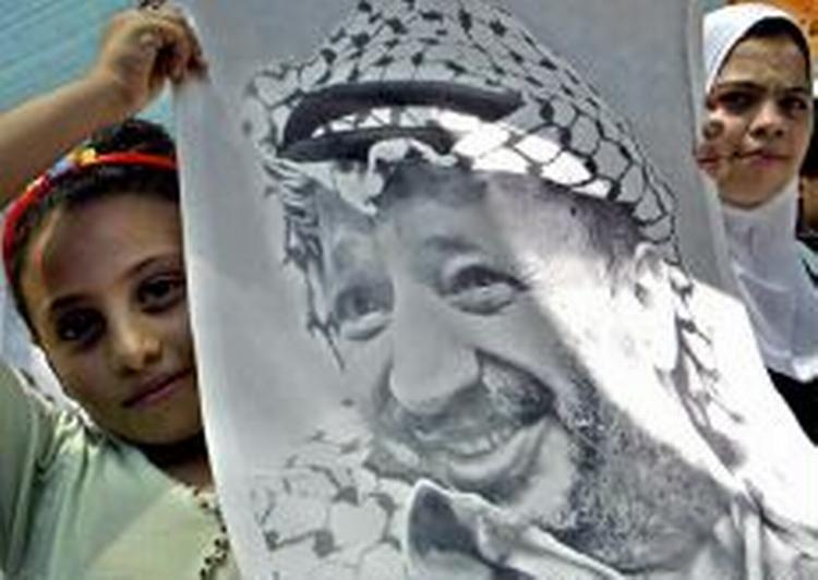 Palæstinensiske piger fremviser et billede af palæstinenserleder Arafat i Gaza By. - Foto: AP 
