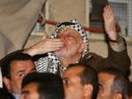 Arafat nægter at forlade hovedkvarteret og Ramallah. Her sender han luftkys til sine tilhængere. - Foto: AP 