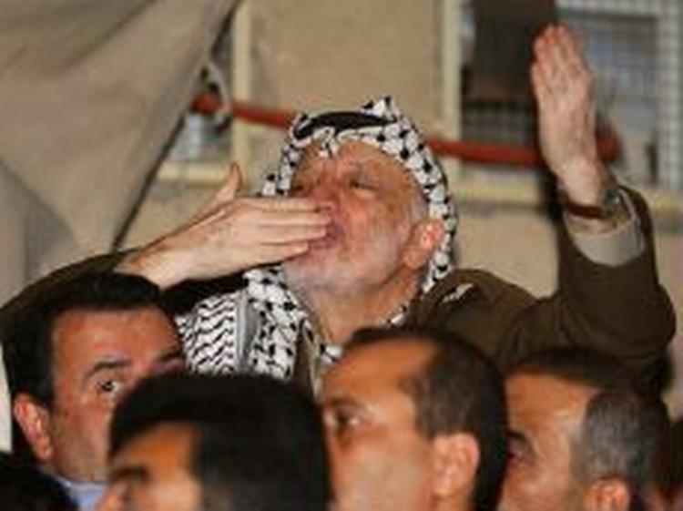 Arafat nægter at forlade hovedkvarteret og Ramallah. Her sender han luftkys til sine tilhængere. - Foto: AP 
