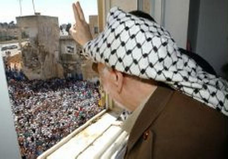 Yassir Arafat, der her vinker ud til sine støtter i Ramallah p åVestbredden, er en trussel mod køreplanen for fred, mener israelerne. - Foto: AP 