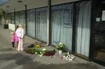 Lokale lægger blomster ved banken, hvor en familiefar i juni sidste år blev skudt og dræbt i sin bil. - Arkivfoto: Gert Jensen 