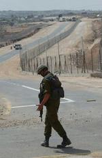 En soldat patruljerer langs den 250 km. lange mur, der også vil omfatte de nye huse i de israelske bosættelser på Vestbredden. - Foto: AP 