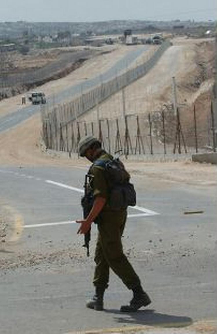 En soldat patruljerer langs den 250 km. lange mur, der også vil omfatte de nye huse i de israelske bosættelser på Vestbredden. - Foto: AP 