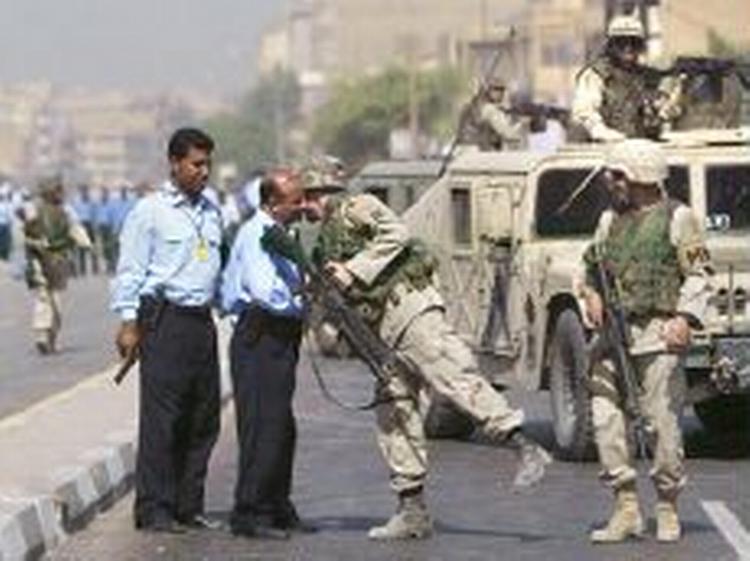 En amerikansk soldat hilser på en irakisk politichef på gaden i Bagdad. - Foto: AP 