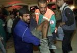 Palæstinensere hjælper en såret mand på sygehuset efter lørdagens sammenstød i Gaza. - Foto: AP 