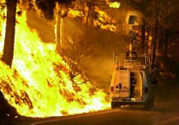 En bil fra tv-stationen KNBC er her blevet fanget af flammerne. - Foto: AP 