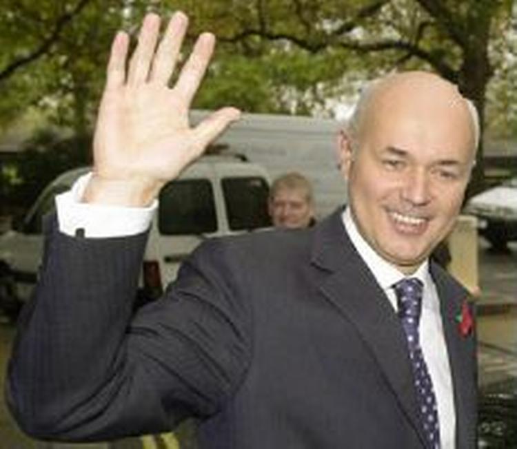 Iain Duncan Smith vinker til fotograferne inden det møde hos de britiske konservative, der kan besegle Smiths skæbne som leder. - Foto: AP 