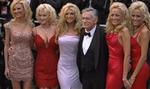 Hugh Hefner, som vi kender ham   omgivet af Playboymodeller. Hans blad er trængt, og nu vil han skaffe sig gratis reklame ved at promovere burgere og andre produkter.   Foto: Finn Frandsen 