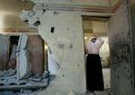 En palæstinensisk kvinde står i døråbningen til sit hjem efter den israelske aktion i og omkring Maghazi-lejren fredag morgen. - Foto: AP 