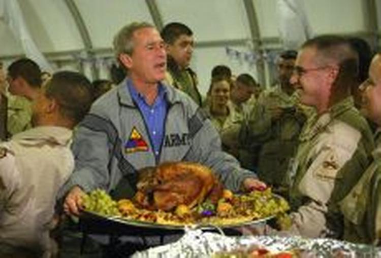 George Bush fik sig en portion kalkun, der er den traditionelle spise til 'Thanksgiving'. - Foto: AP 