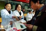 Kinesisk sundhedspersonale deler materiale ud i Shanghai. - Foto: AP 