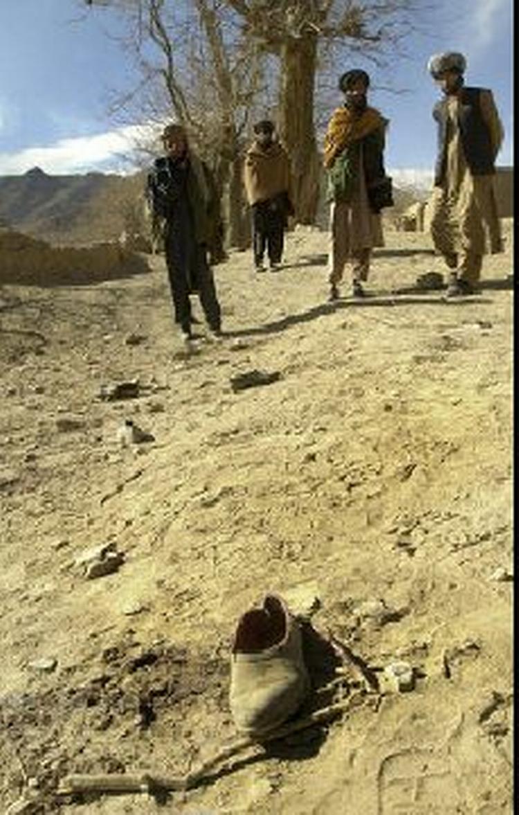 Afghanske mænd betragter sko og tøj fra de dræbte børn. - Foto: AP 