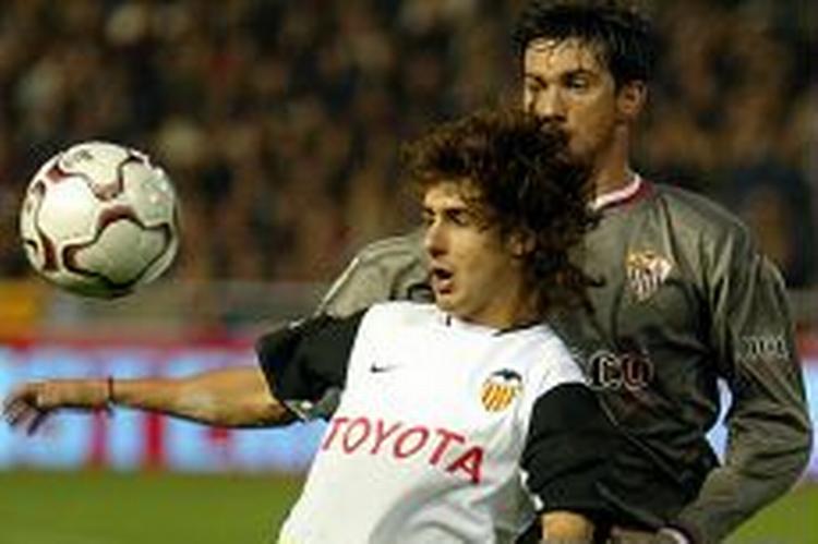 Valencias argentinske spiller Pablo Aimar holder Sevilla-spilleren væk fra bolden. - Foto: AP 