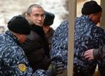Mikhail Khodorkovskij (uden hue) eskorteres til retten. - Foto: AP 
