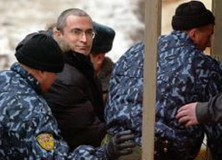 Mikhail Khodorkovskij (uden hue) eskorteres til retten. - Foto: AP 
