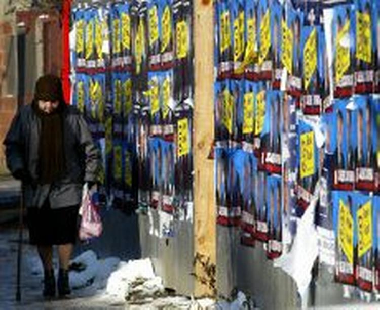 En kvinde passerer en væg med valgplakater i Beograd. - Foto: AP 