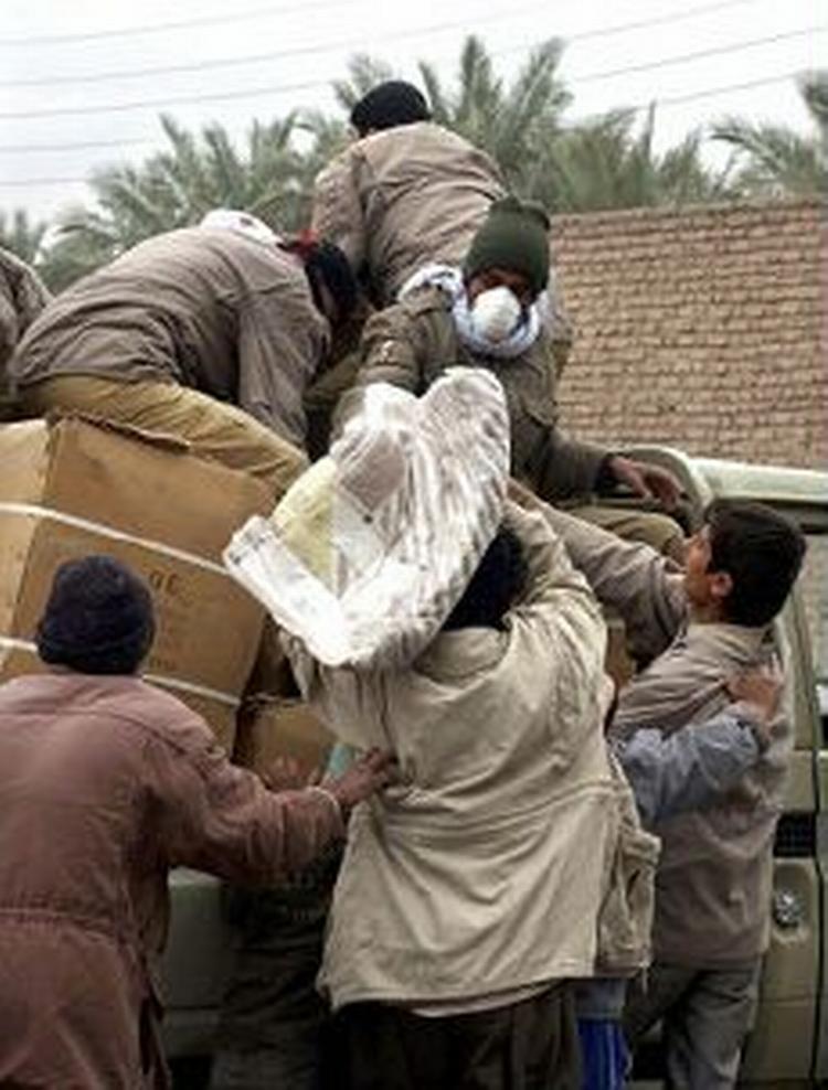 Iranske soldater udleverer tæpper til nogle af de mange hjemløse i Bam. - Foto: AP 