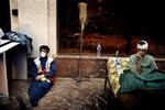 Mens 14-årige Babach Asady (th.) kommer til hægterne efter tre døgn i ruinerne, snupper en af plejepersonalet sig en blund i nødhospitalet i Bams Lufthavn. - Foto: Jan Grarup 