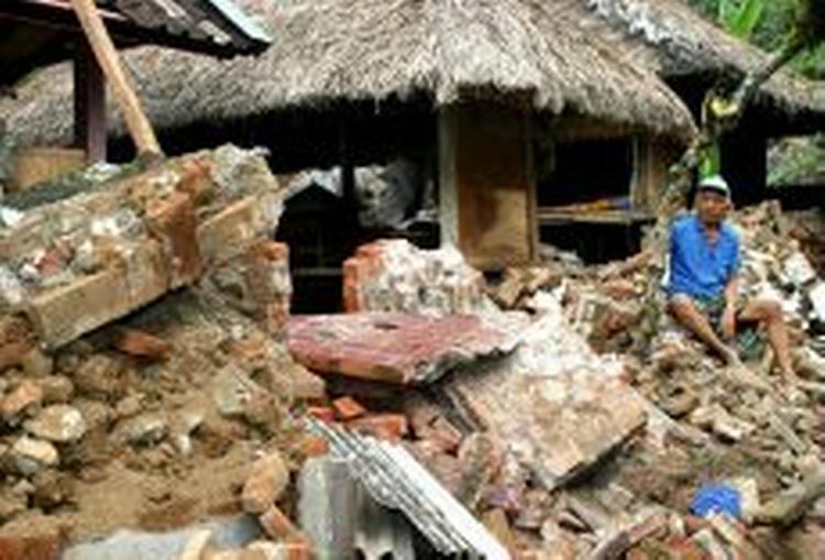 En balinesisk mand kigger på resterne af sit hus, der bukkede under ved jordskælvet. - Foto: AP 