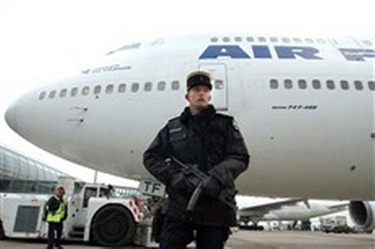 En gendarm på vagt ved et Air France-fly med destination Los Angeles i Paris  Charles de Gaulle-lufthavn fredag. Air France aflyste flere afgange på ruten lige før jul på grund af advarsler om terrorrisiko. - Foto: AP 