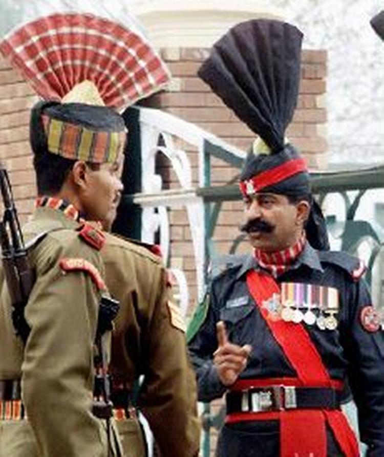 En pakistansk soldat (th.) veksler et ord med en indisk grænsesoldat i forbindelse med et møde, der skal bane vejen for mere handel i regionen. - Foto: AP 