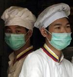 Fødevaresælger i Guangzhou bærer masker af frygt for at blive smittet med sygdommen sars. - Foto AP 