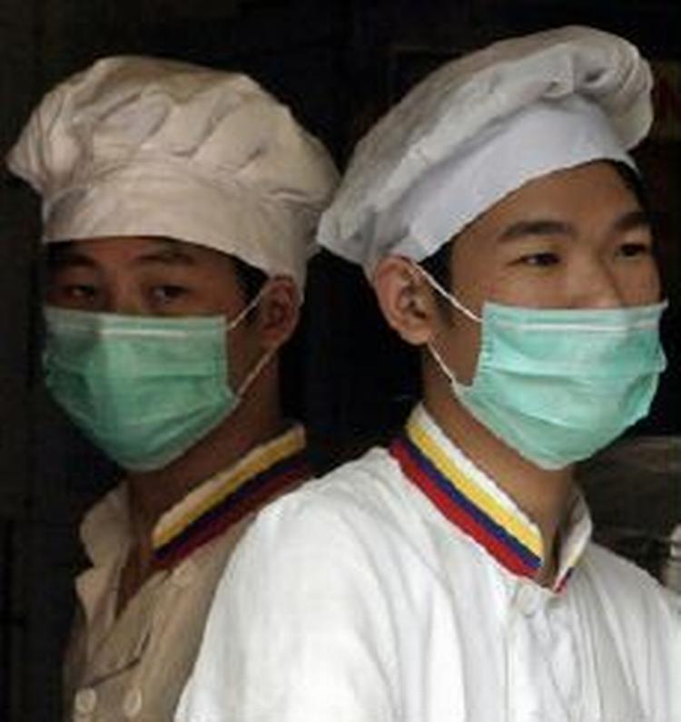 Fødevaresælger i Guangzhou bærer masker af frygt for at blive smittet med sygdommen sars. - Foto AP 