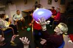 Ulla Bai Jensen på 84 år dasker til ballonen under sin ugentlige gymnastiktime på nærgymnastikholdet i Vanløse i går. Da ballonerne skal sprænges, kommer Inga Nielsen på 79 til undsætning med sin broc 