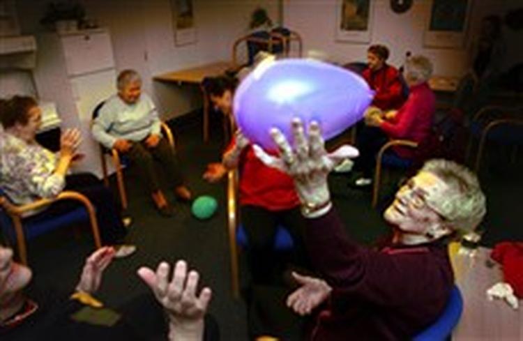 Ulla Bai Jensen på 84 år dasker til ballonen under sin ugentlige gymnastiktime på nærgymnastikholdet i Vanløse i går. Da ballonerne skal sprænges, kommer Inga Nielsen på 79 til undsætning med sin broc 