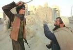 En civil afghaner får tæv af en talebaner for at være i besiddelse af opium. - Arkivfoto: AP 