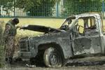En irakisk soldat studerer et bilvrag i Samarra, hvor en bilbombe dræbte fire irakere og sårede 33. - Foto: AP 