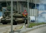 En israelsk kampvogn i kamp med palæstinensiske militante i udkanten af Gaza By. - Foto: AP 
