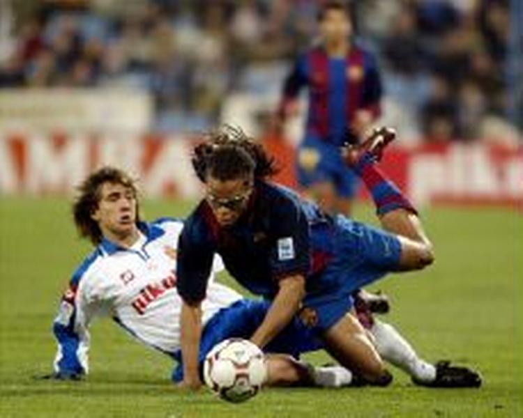 Barcelonas nyeste hollænder, Davids, takles af en Zaragoza-spiller. - Foto: AP 