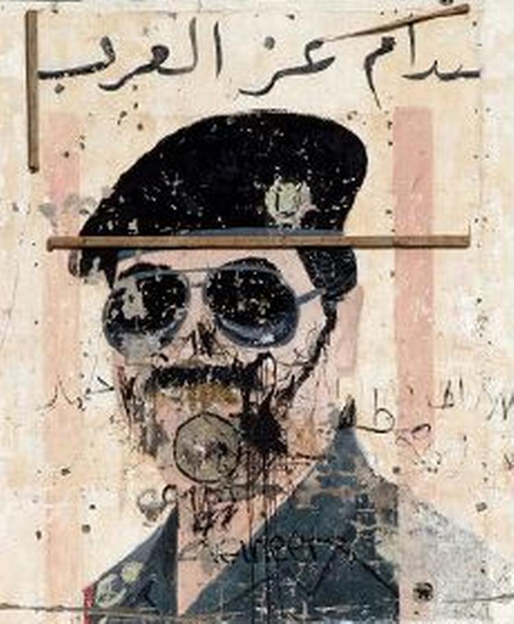 En ødelagt plakat med Saddam Hussein. - Foto: AP 