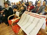 »Hvem tager ansvaret for disse 155 menneskeliv?«, står der på plakaten, som pårørende havde med i retssalen. - Foto: AP 