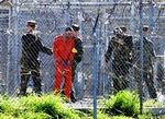 Fanger i orange dragter med bind for øjne og ører ved modtagelsen i Guantánamo. De får ikke at vide, hvor de befinder sig   kun at de er 12.773 kilometer fra Mekka.   Foto: Shane T. McCoy 