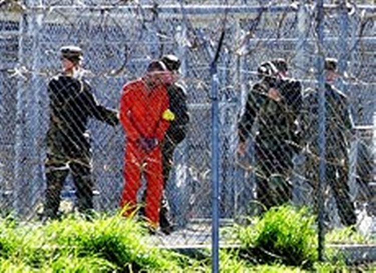 Fanger i orange dragter med bind for øjne og ører ved modtagelsen i Guantánamo. De får ikke at vide, hvor de befinder sig   kun at de er 12.773 kilometer fra Mekka.   Foto: Shane T. McCoy 