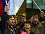 Serbiske ultranationalister hylder det serbiske flag under et valgmøde. De vandt valget i december, men kunne ikke samle flertal for en regering. En bred koalition skal holde dem fra magten.   Foto: Srdjan Ilic, AP 