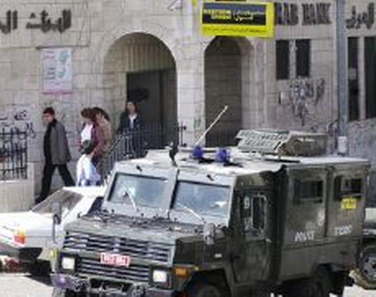 Israelske soldater beordrer folk ud af en af bankerne. - Foto: AP 